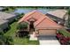 Charming single-Gathering home with a red tile roof, lush landscaping, and a well-maintained lawn at 5733 White Jasmine Way, North Port, FL 34287