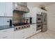 Gourmet kitchen with stainless steel appliances, granite countertops, and white cabinets at 5733 White Jasmine Way, North Port, FL 34287