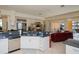 Bright kitchen with white cabinetry and stainless appliances that opens to the spacious living room with pool views at 5733 White Jasmine Way, North Port, FL 34287