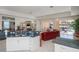 Bright kitchen with white cabinetry and stainless appliances that opens to the spacious living room with pool views at 5733 White Jasmine Way, North Port, FL 34287