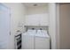 Functional laundry room with washer, dryer, overhead cabinets, and neutral color palette at 5733 White Jasmine Way, North Port, FL 34287