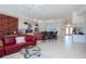 Open-concept living space with a red sofa, tile flooring, and a breakfast bar area overlooking the kitchen at 5733 White Jasmine Way, North Port, FL 34287