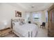 Airy main bedroom features a decorative bed frame, tray ceiling, and windows with a view of the outdoors at 5733 White Jasmine Way, North Port, FL 34287
