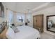 Bright main bedroom featuring tray ceiling, decorative pillows and a large wardrobe at 5733 White Jasmine Way, North Port, FL 34287