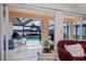 Screened patio with a pool and lake view through sliding glass doors; neutral tile flooring throughout at 5733 White Jasmine Way, North Port, FL 34287