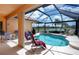A screened-in pool with lounge chairs, overlooking a serene lake and lush landscaping at 5733 White Jasmine Way, North Port, FL 34287