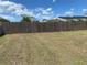 A spacious backyard with well-maintained lawn, fully enclosed by a tall wood fence for privacy at 6327 Fabian Rd, North Port, FL 34287