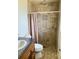 Bathroom with a tiled shower, toilet, and vanity with sink, showcasing clean lines and neutral colors at 6327 Fabian Rd, North Port, FL 34287