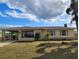 Charming home with well-manicured lawn, mature landscaping, and attached carport at 6327 Fabian Rd, North Port, FL 34287