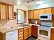 Well-maintained kitchen featuring wooden cabinetry, a microwave, and tiled backsplash at 6327 Fabian Rd, North Port, FL 34287