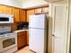 Functional kitchen featuring wooden cabinets and white appliances for easy meal preparation at 6327 Fabian Rd, North Port, FL 34287