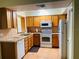 Functional kitchen with wooden cabinets, white appliances, and tiled flooring at 6327 Fabian Rd, North Port, FL 34287