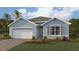 Charming single-story home featuring a brick driveway, attached garage, and lush landscaping at 9510 Turtle Grass Cir, Punta Gorda, FL 33950