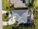 Aerial view of a home with a pool, a driveway, palm trees and lush green grass at 1091 Rotonda Cir, Rotonda West, FL 33947