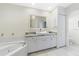 Modern bathroom features a double sink vanity with granite countertop and tiled floors at 1091 Rotonda Cir, Rotonda West, FL 33947
