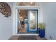 Open entryway featuring blue double doors with decorative glass, brick steps, and a glimpse into the bright interior at 1091 Rotonda Cir, Rotonda West, FL 33947