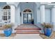 Close up of the inviting brick-lined entryway with double doors, decorative columns, and potted plants at 1091 Rotonda Cir, Rotonda West, FL 33947