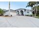 Charming single-story home featuring a three-car garage, an elegant front entrance, and lush landscaping at 1091 Rotonda Cir, Rotonda West, FL 33947