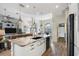 Bright open concept kitchen with stainless appliances, island seating, and wood look floors at 1091 Rotonda Cir, Rotonda West, FL 33947