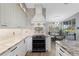 Elegant kitchen with white cabinetry, granite countertops, and stainless steel appliances at 1091 Rotonda Cir, Rotonda West, FL 33947