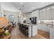 Bright, open kitchen featuring a center island with bar seating, granite countertops, modern appliances, and white cabinetry at 1091 Rotonda Cir, Rotonda West, FL 33947