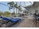 Inviting outdoor living space with screened-in patio, lounge chairs, and a view of the serene pond at 1091 Rotonda Cir, Rotonda West, FL 33947