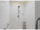 Bright tiled shower features handrails, showerhead, and convenient shelving at 1091 Rotonda Cir, Rotonda West, FL 33947