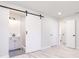 Bathroom with barn door entry, vanity and shower with modern fixtures and white subway tile at 1357 Nimrod St, Port Charlotte, FL 33952