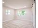 Bright bedroom with neutral walls, wood-look floors, and natural light from two windows at 1357 Nimrod St, Port Charlotte, FL 33952