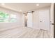 Bedroom featuring a barn door to the bathroom and wood-look flooring at 1357 Nimrod St, Port Charlotte, FL 33952