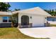 Attached garage with white door and stone accents, complemented by a concrete driveway and manicured lawn at 1357 Nimrod St, Port Charlotte, FL 33952