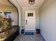 Inviting front porch with a charming welcome mat, stylish light fixture, and tasteful decor at 1357 Nimrod St, Port Charlotte, FL 33952