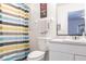 Clean bathroom features a functional sink and vanity and a shower with a colorful shower curtain at 1721 Nicollett Ave, North Port, FL 34286
