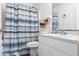 Bright bathroom with a blue striped shower curtain, white cabinets, and a clean, well-lit mirror at 1721 Nicollett Ave, North Port, FL 34286