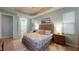 Spacious main bedroom features a tray ceiling, light blue walls, and ensuite bathroom at 17420 Jadestone Ct, Venice, FL 34293