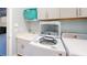 A laundry room equipped with a sink, storage cabinets, a washing machine, and a dryer at 17420 Jadestone Ct, Venice, FL 34293
