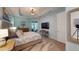 This spacious main bedroom has wood floors, a TV, direct access to the patio, and is decorated in relaxing beach colors at 17420 Jadestone Ct, Venice, FL 34293