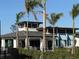 Community clubhouse restaurant with outdoor seating behind tall palm trees at 17420 Jadestone Ct, Venice, FL 34293