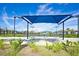Scenic view of community tennis courts with shelter, benches, lush landscaping, and convenient lighting for evening matches at 17420 Jadestone Ct, Venice, FL 34293