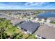 Aerial view of a neighborhood with houses, palm trees, green spaces, and a lake in a planned community at 1796 W Palms Dr, Port Charlotte, FL 33953