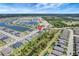 Aerial view of a neighborhood with houses, palm trees, green spaces, and waterways in a planned community at 1796 W Palms Dr, Port Charlotte, FL 33953