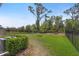 Fenced backyard features healthy lawn, young trees, and tidy shrubbery, providing privacy and a lush outdoor space at 1796 W Palms Dr, Port Charlotte, FL 33953