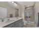 Bathroom with a double sink vanity, large mirror, and a glass-enclosed shower at 1796 W Palms Dr, Port Charlotte, FL 33953