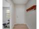Bright hallway with wood-look flooring, a coat rack, and a view into the adjacent room at 1796 W Palms Dr, Port Charlotte, FL 33953