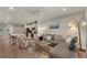 Open-concept living room featuring a gray sectional, stylish decor, and seamless flow to the kitchen at 1796 W Palms Dr, Port Charlotte, FL 33953