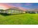 Picturesque backyard with lush lawn, neat landscaping and screened patio at 1940 Scarlett Ave, North Port, FL 34289