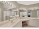 Bright bathroom features dual sinks, makeup vanity, large mirrors, and walk-in shower at 1940 Scarlett Ave, North Port, FL 34289