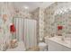 Charming bathroom with floral wallpaper, shower with curtain and white vanity at 1940 Scarlett Ave, North Port, FL 34289