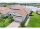 Beautiful single-story home with a lake view, tiled roof, paved driveway, and an attached two-car garage at 1940 Scarlett Ave, North Port, FL 34289