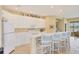 Bright kitchen features white cabinetry, a breakfast bar with seating, and modern appliances at 1940 Scarlett Ave, North Port, FL 34289
